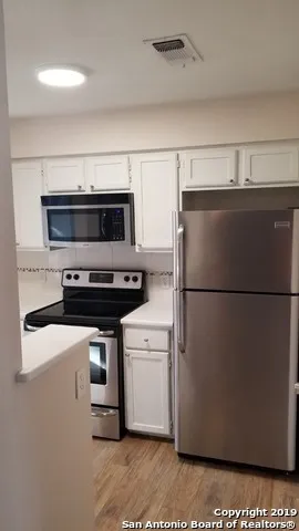 a kitchen with a refrigerator and a stove top oven