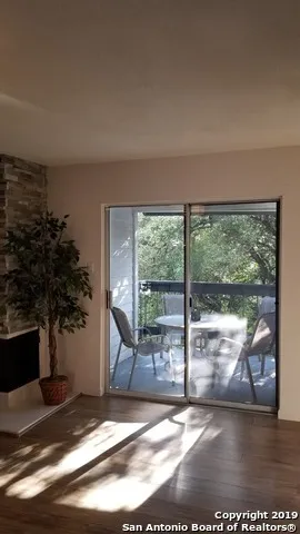 a view of a livingroom with wooden floor and floor to ceiling window