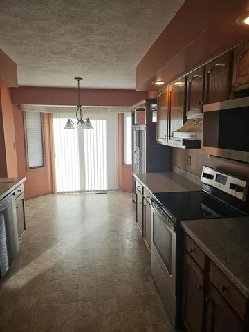 a kitchen with stainless steel appliances granite countertop a sink and a stove