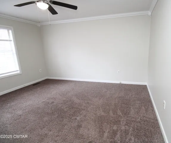 an empty room with a ceiling fan and a window