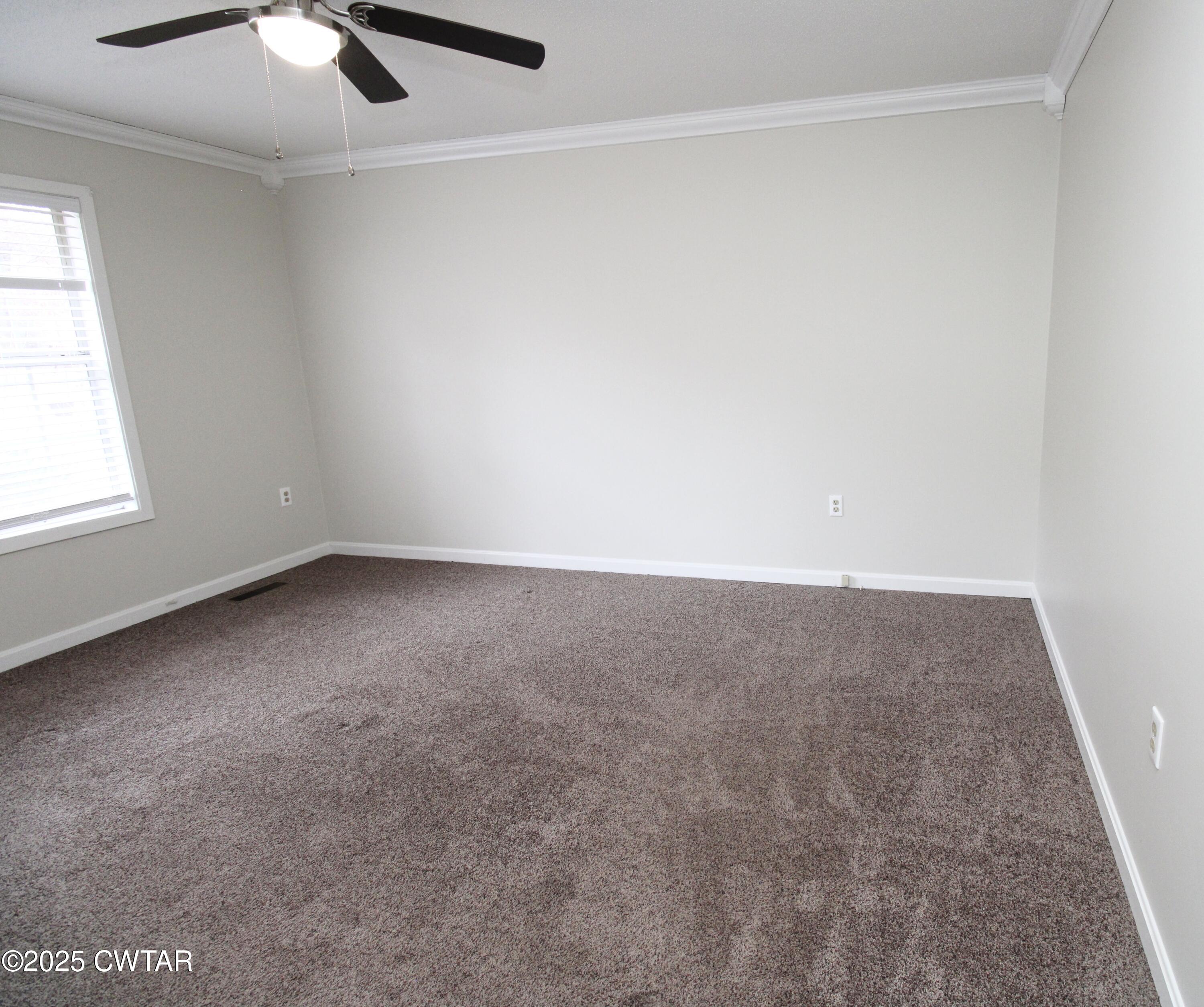 311 Elizabeth Circle Lexington, TN 38351 - Photo 11 of 23 an empty room with a ceiling fan and a window