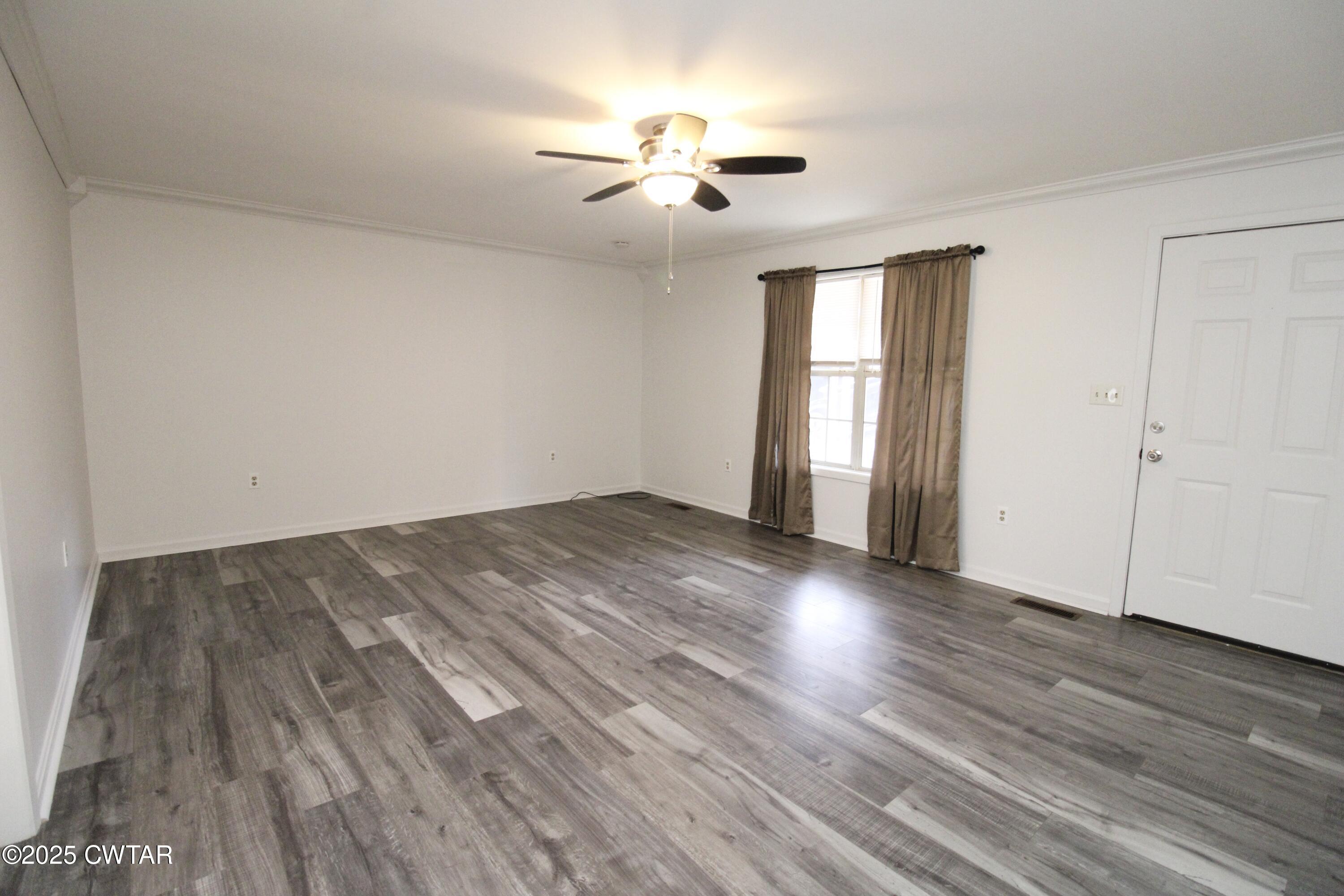 311 Elizabeth Circle Lexington, TN 38351 - Photo 2 of 23 an empty room with wooden floor and windows