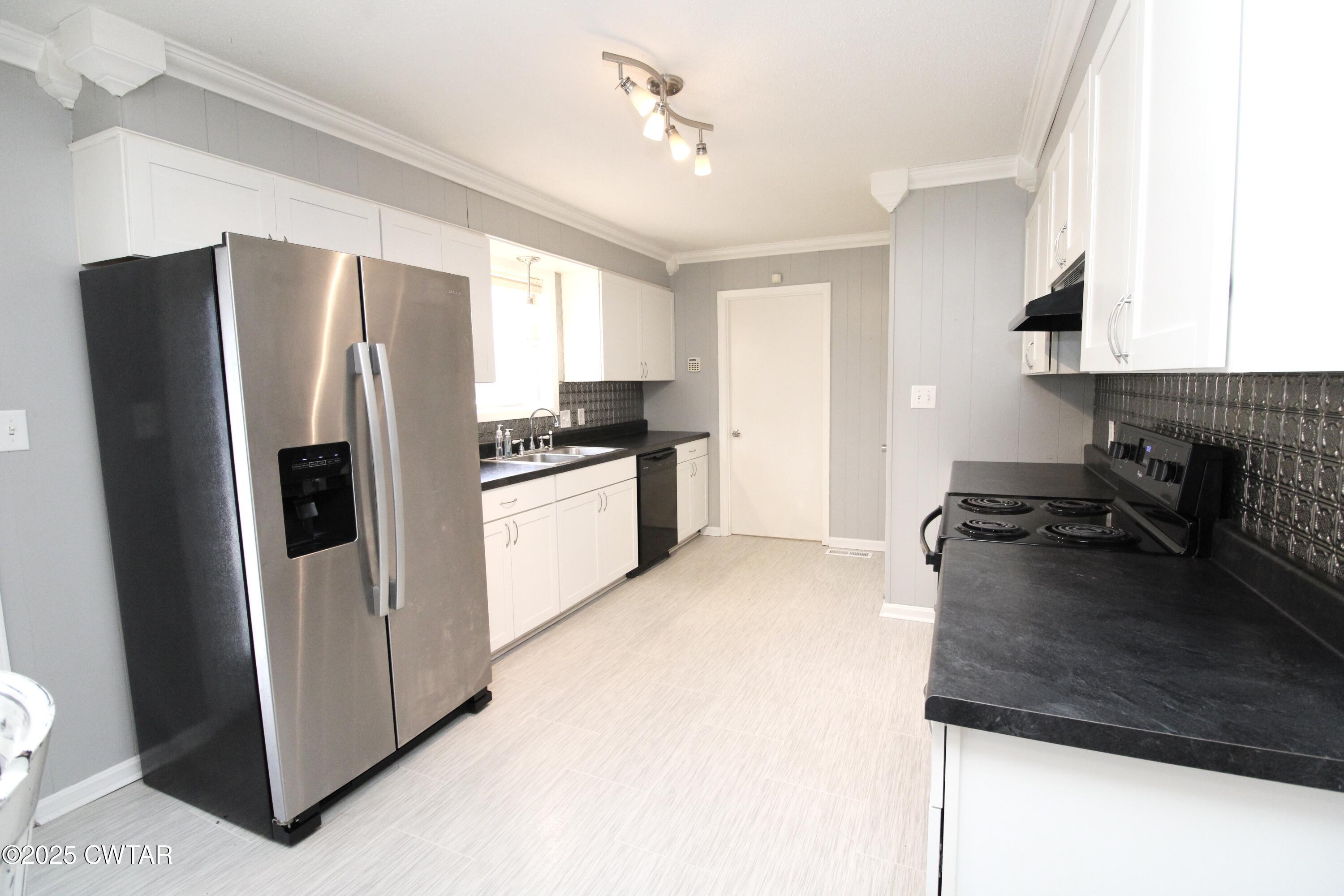 311 Elizabeth Circle Lexington, TN 38351 - Photo 6 of 23 a kitchen with stainless steel appliances granite countertop a refrigerator a stove a sink and a microwave