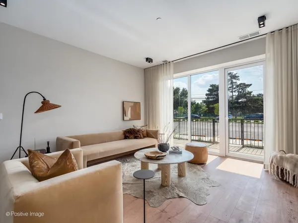 a living room with furniture a table and kitchen view