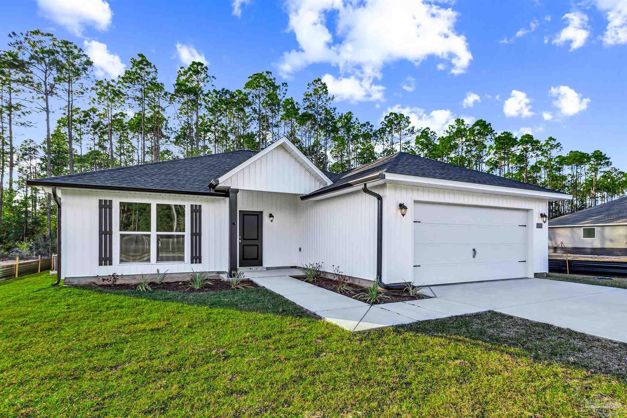 a view of a house with a yard and potted plants