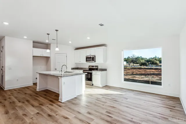 a kitchen with stainless steel appliances kitchen island wooden cabinets and granite counter tops