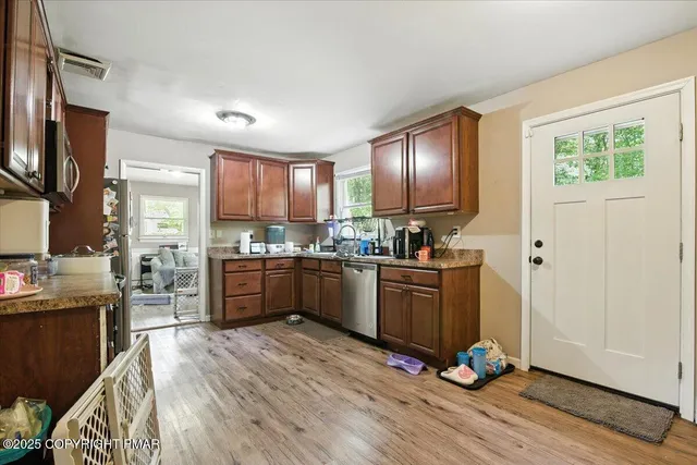 a kitchen with stainless steel appliances granite countertop a sink stove and wooden cabinets