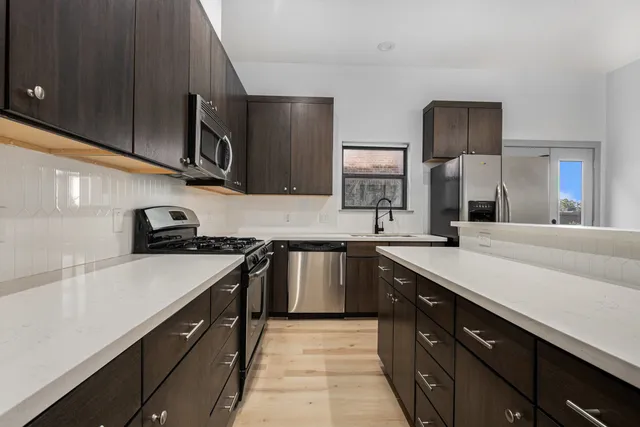a kitchen with stainless steel appliances granite countertop a sink stove and refrigerator