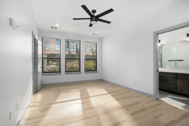 a view of an empty room with window and cabinet