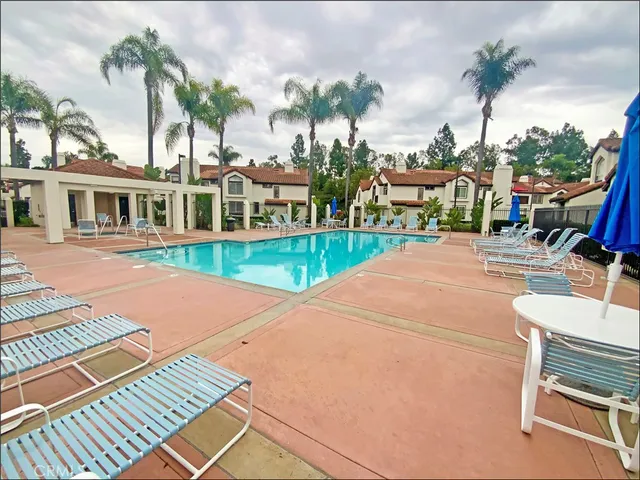 a view of a white house with a yard patio and swimming pool