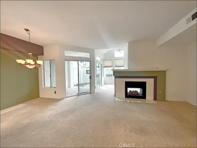 a view of an empty room with a fireplace and a window