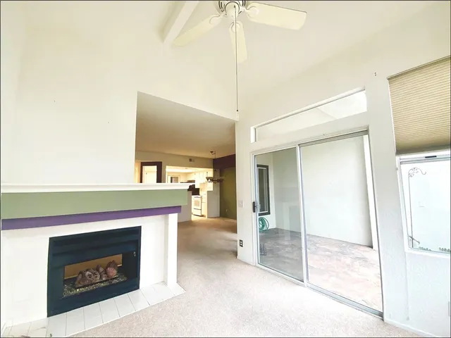 a living room with a fireplace and a ceiling fan