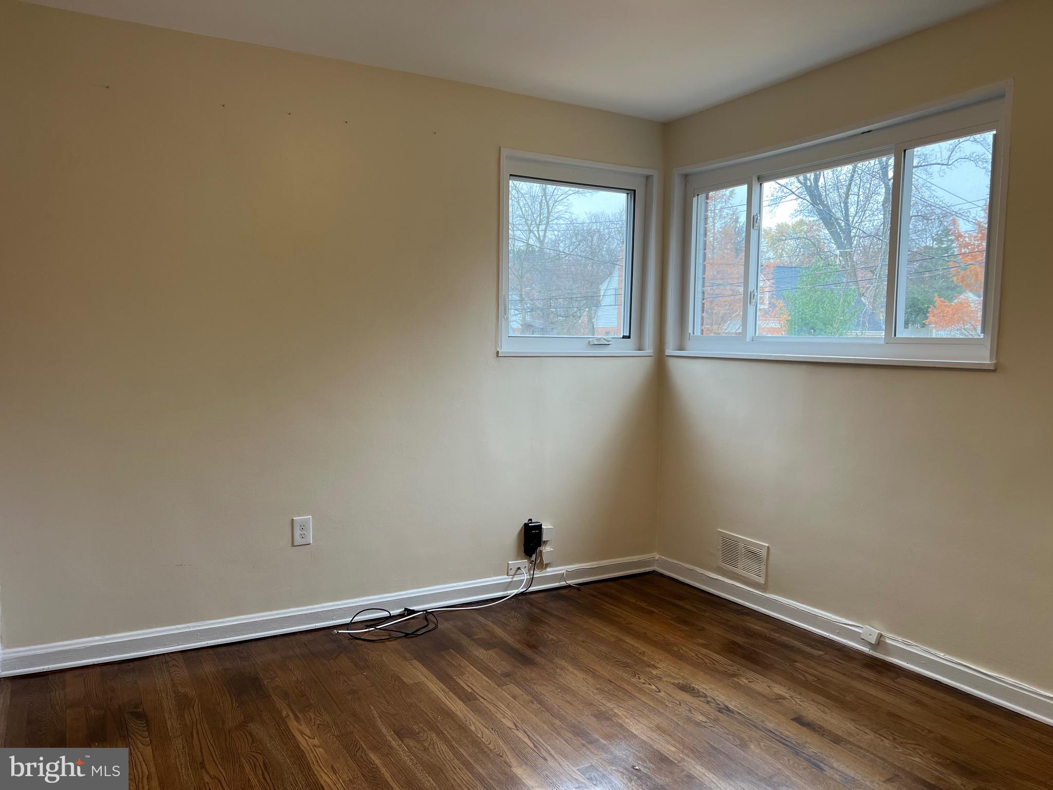 10713 St Margarets Way Silver Spring, MD 20902 - Photo 12 of 20 a view of an empty room with wooden floor and a window