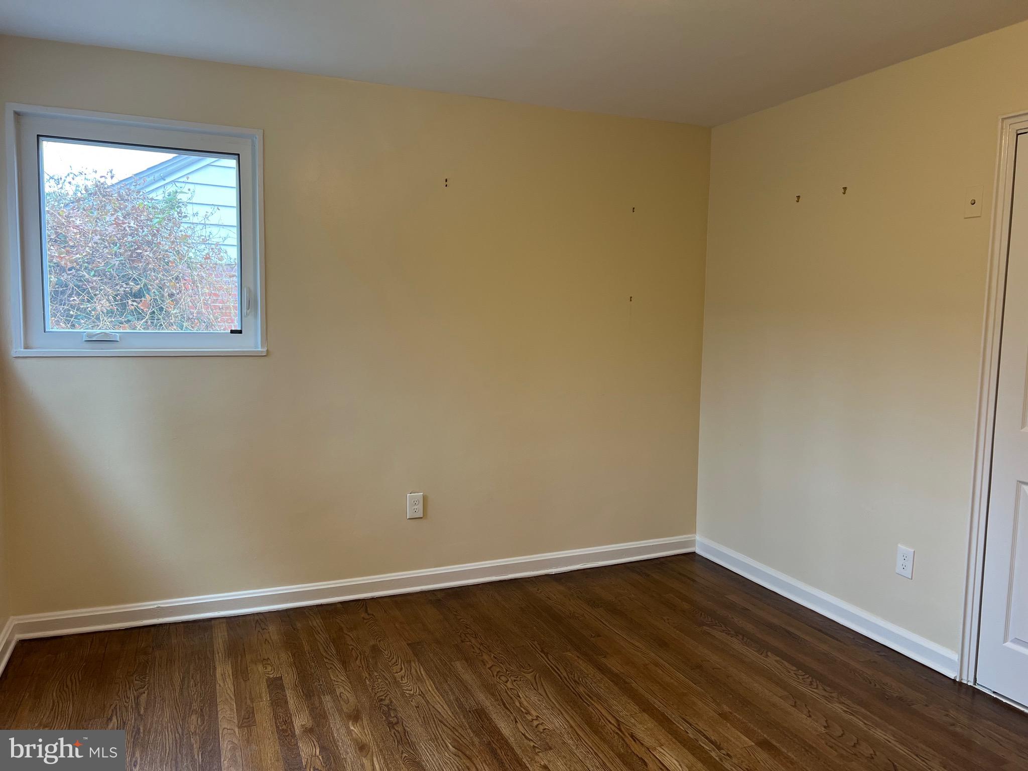 10713 St Margarets Way Silver Spring, MD 20902 - Photo 10 of 20 a view of an empty room with wooden floor and a window