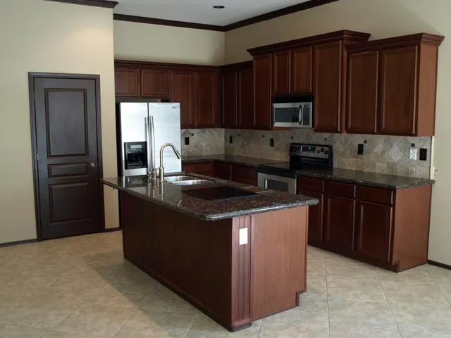 a kitchen with granite countertop wooden cabinets and stainless steel appliances
