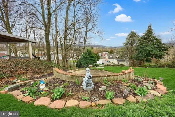 a view of a house with backyard sitting area and garden