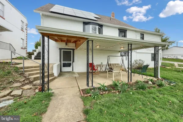a view of a house with backyard porch and sitting area