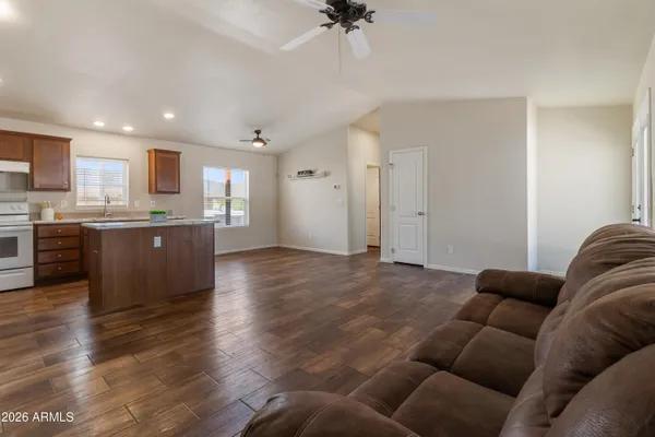 a living room with stainless steel appliances furniture and a kitchen view