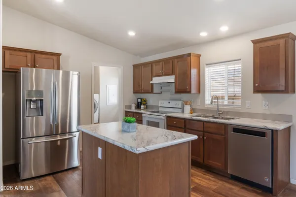 a kitchen with stainless steel appliances granite countertop a sink stove and refrigerator