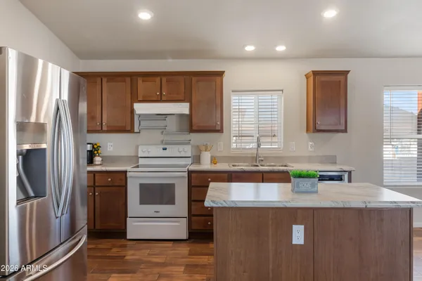 a kitchen that has a sink a stove and a refrigerator