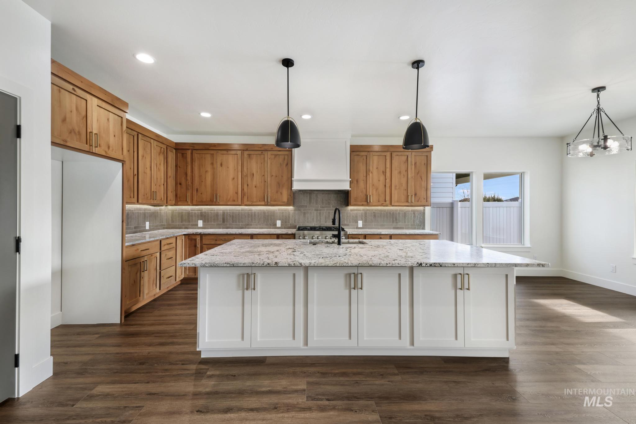 527 Falling Leaf Lane Twin Falls, ID 83301 - Photo 14 of 42 Kitchen with brown cabinetry, white cabinets, pendant lighting, light stone countertops, and recessed lighting