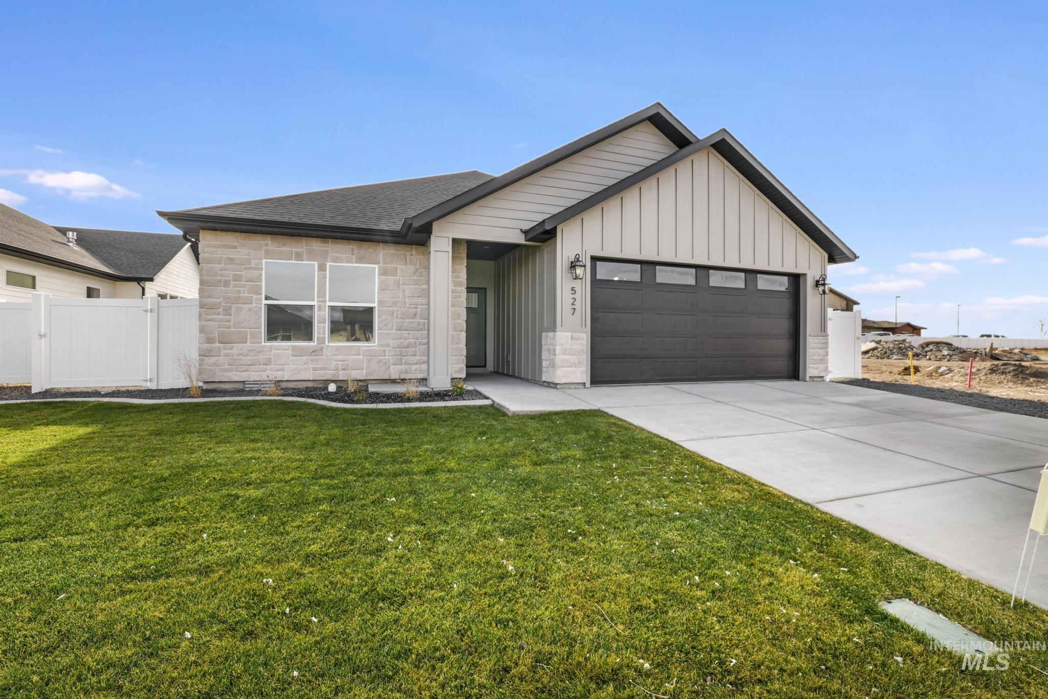 527 Falling Leaf Lane Twin Falls, ID 83301 - Photo 2 of 42 View of front of property with board and batten siding, stone siding, driveway, a garage, and a shingled roof