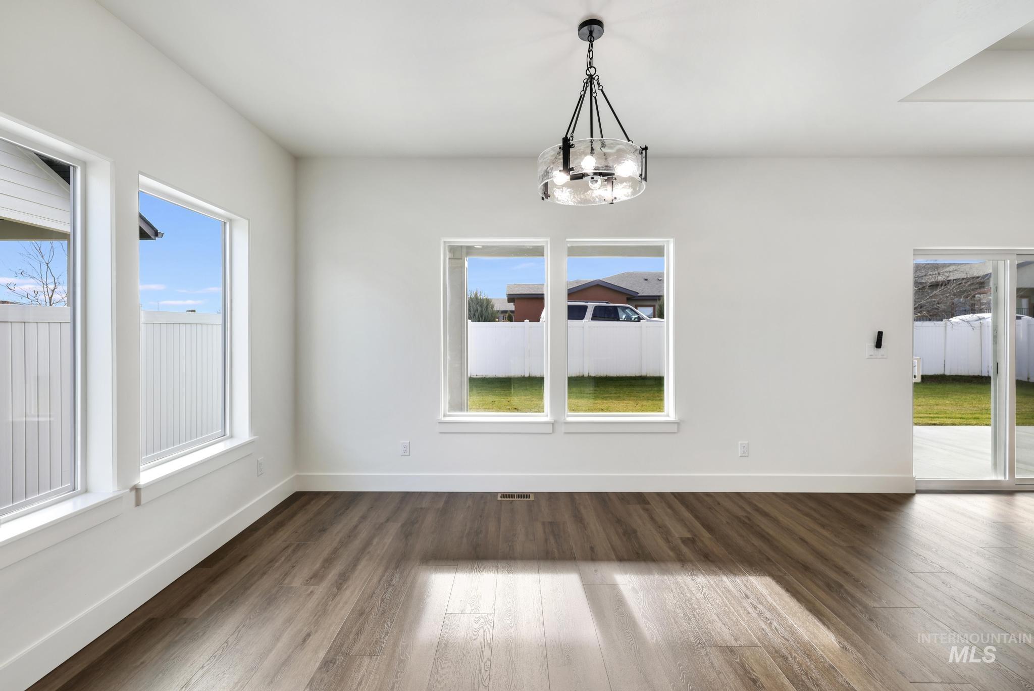 527 Falling Leaf Lane Twin Falls, ID 83301 - Photo 10 of 42 Unfurnished dining area featuring plenty of natural light, dark wood-type flooring, and a chandelier