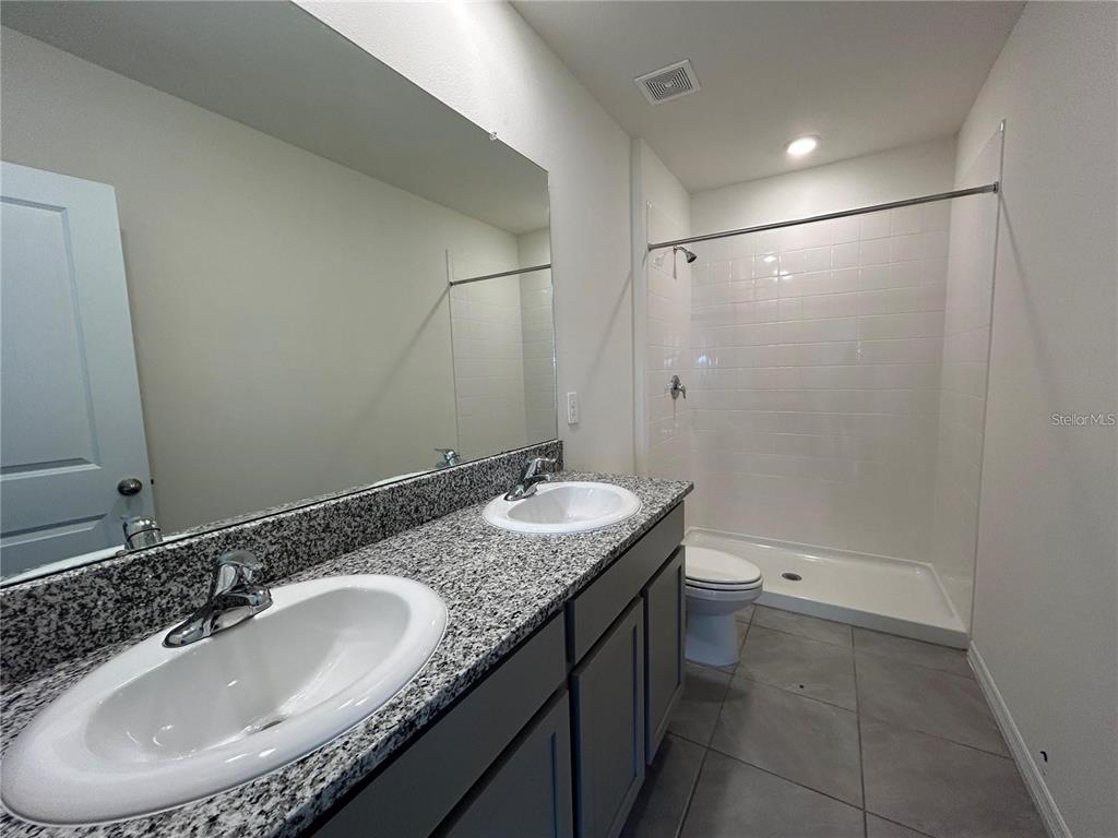 17550 Crescent Moon Loop Bradenton, FL 34211 - Photo 17 of 36 a bathroom with a granite countertop sink and a mirror