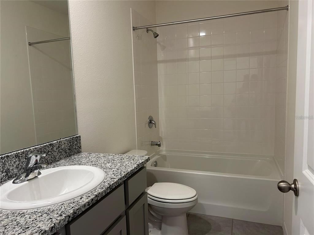 17550 Crescent Moon Loop Bradenton, FL 34211 - Photo 21 of 36 a bathroom with a granite countertop sink toilet and shower