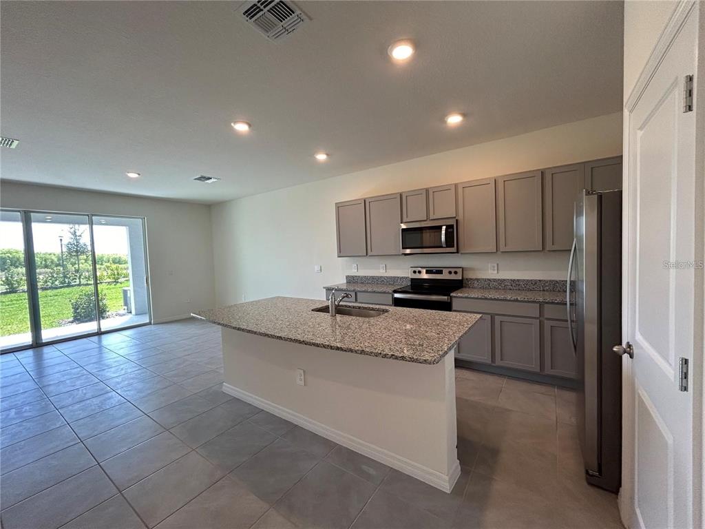 17550 Crescent Moon Loop Bradenton, FL 34211 - Photo 8 of 36 a kitchen with stainless steel appliances granite countertop a sink and a stove
