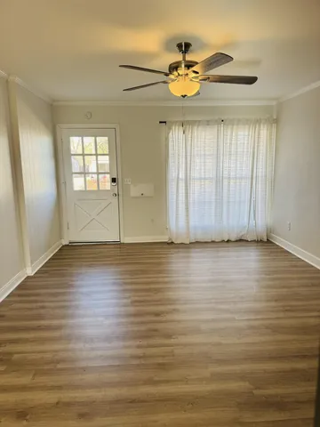 an empty room with wooden floor and windows