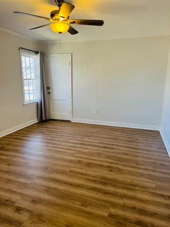 wooden floor in an empty room with a window