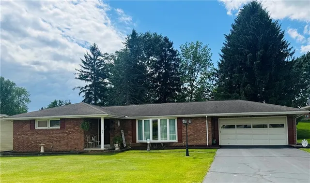 a front view of a house with a garden and yard