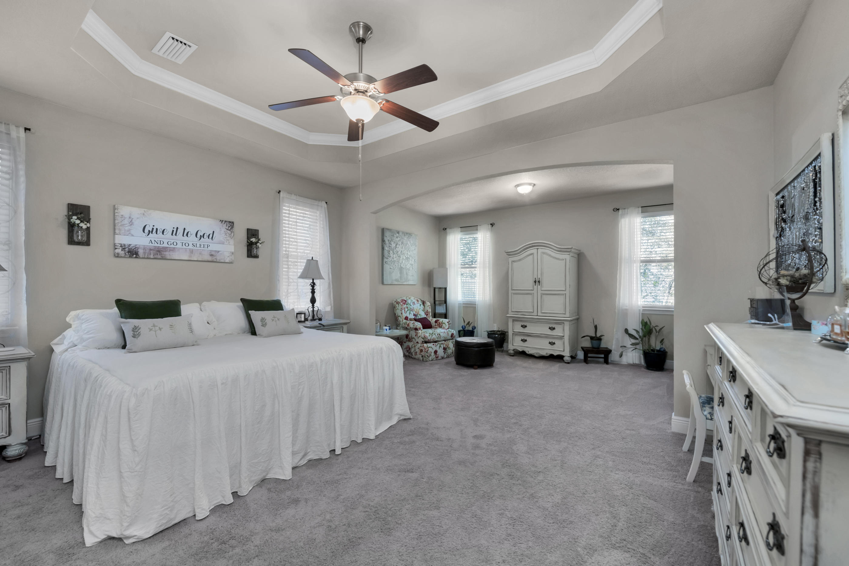 514 Brighton Cove Freeport, FL 32439 - Photo 16 of 32 a spacious bedroom with a bed a ceiling fan and a dresser