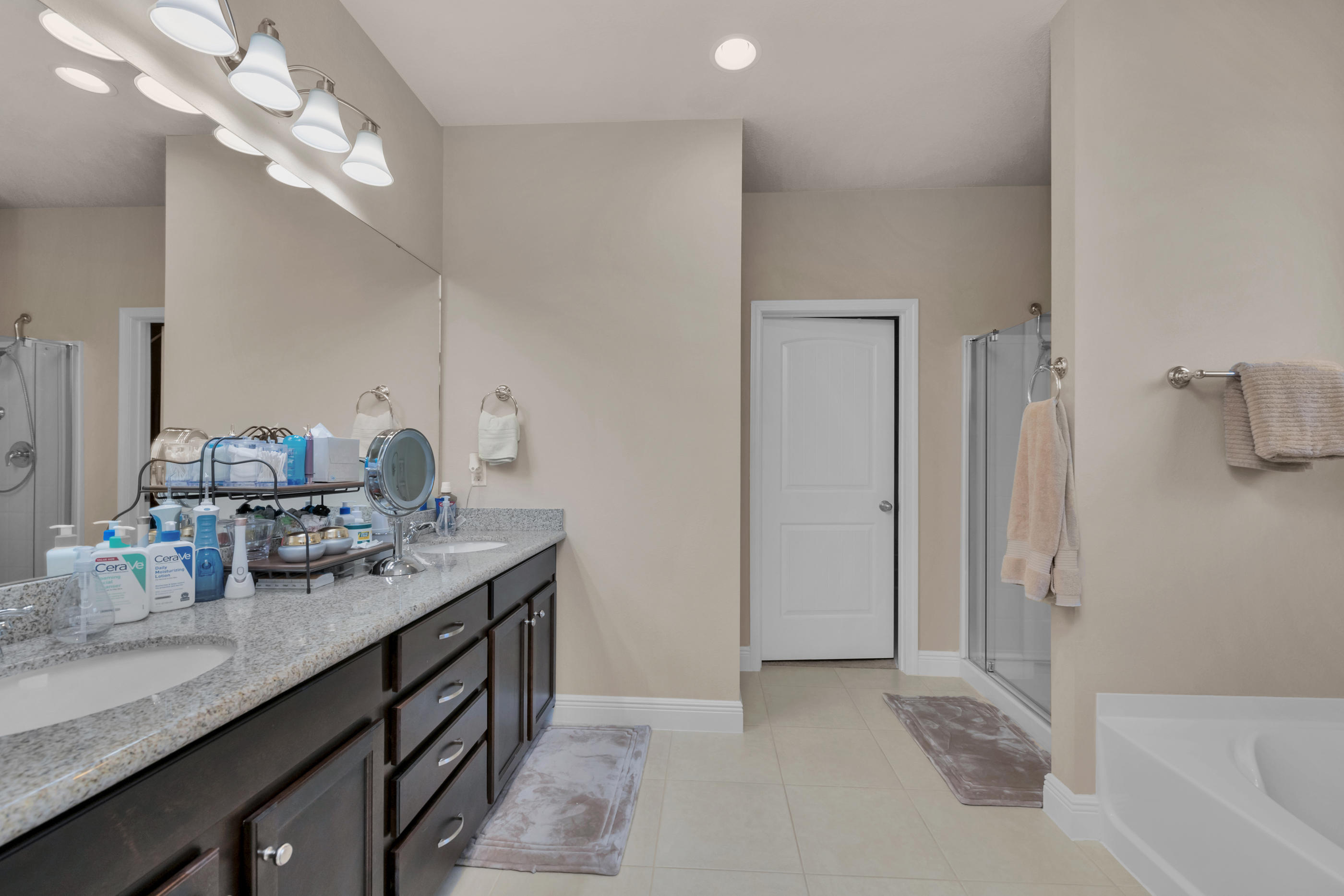 514 Brighton Cove Freeport, FL 32439 - Photo 19 of 32 a bathroom with a granite countertop sink a large mirror and shower