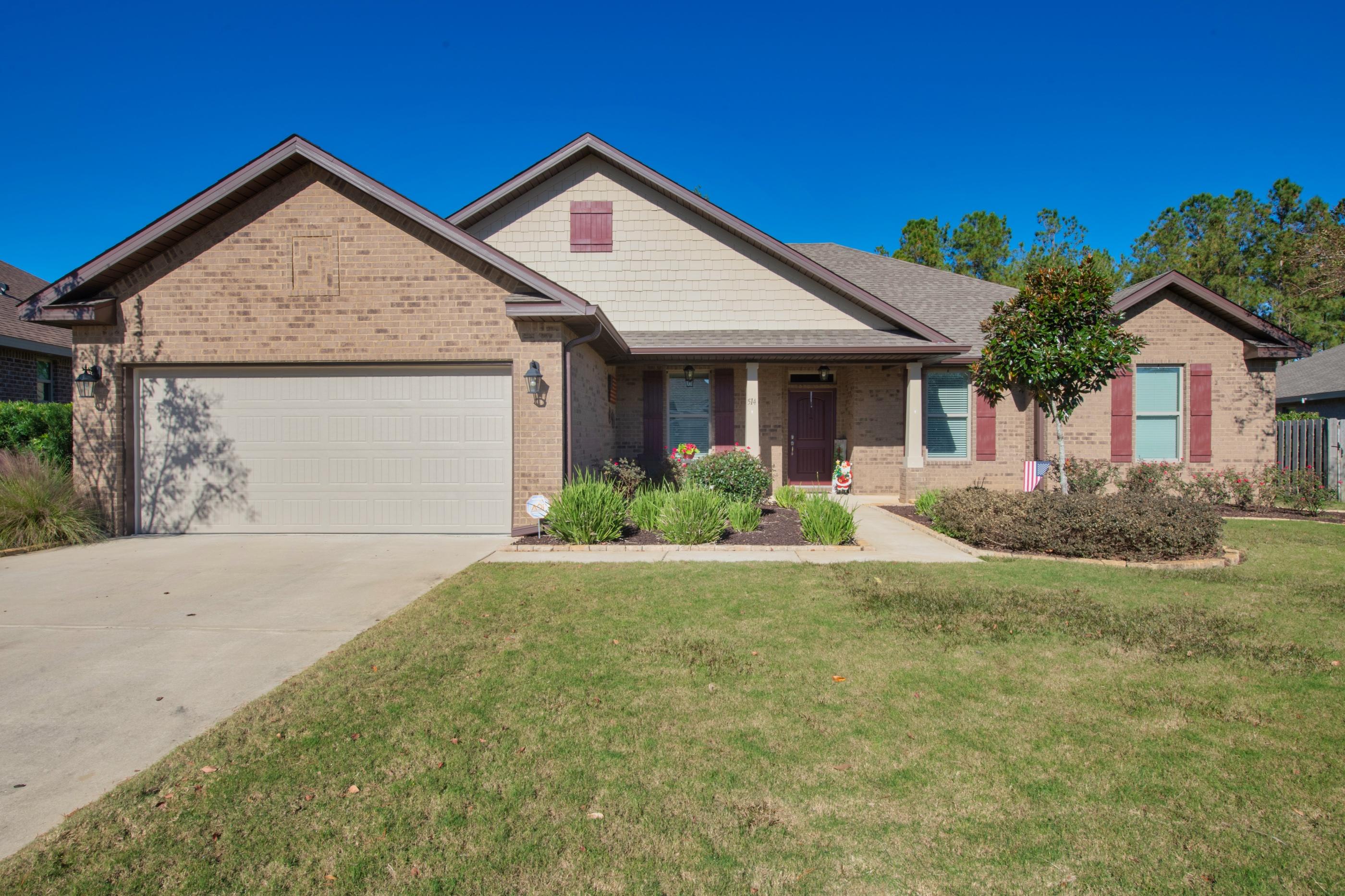 514 Brighton Cove Freeport, FL 32439 - Photo 2 of 32 a front view of a house with a yard and garage