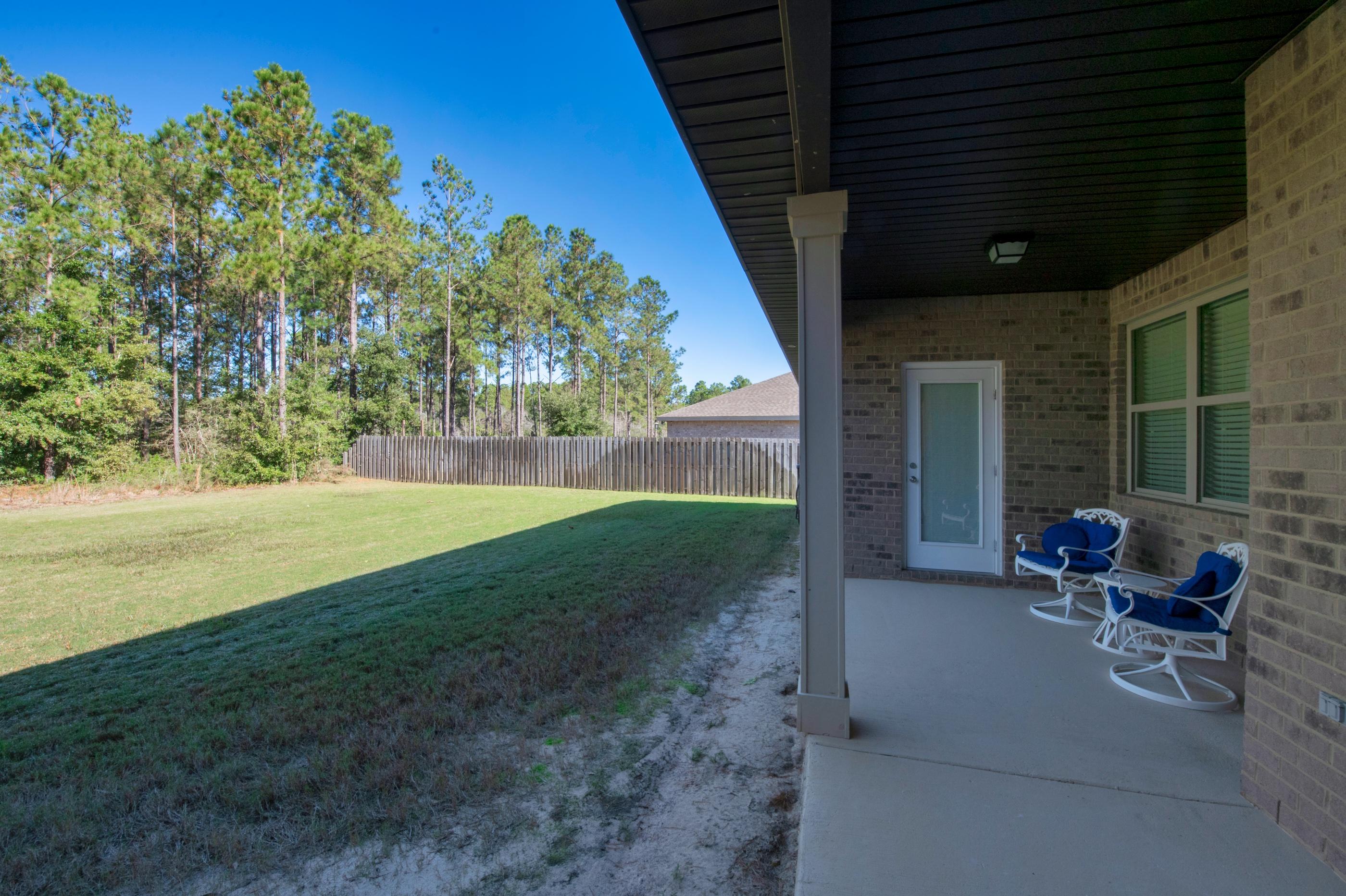 514 Brighton Cove Freeport, FL 32439 - Photo 28 of 32 a view of a patio with table and chairs potted plants and floor to ceiling window