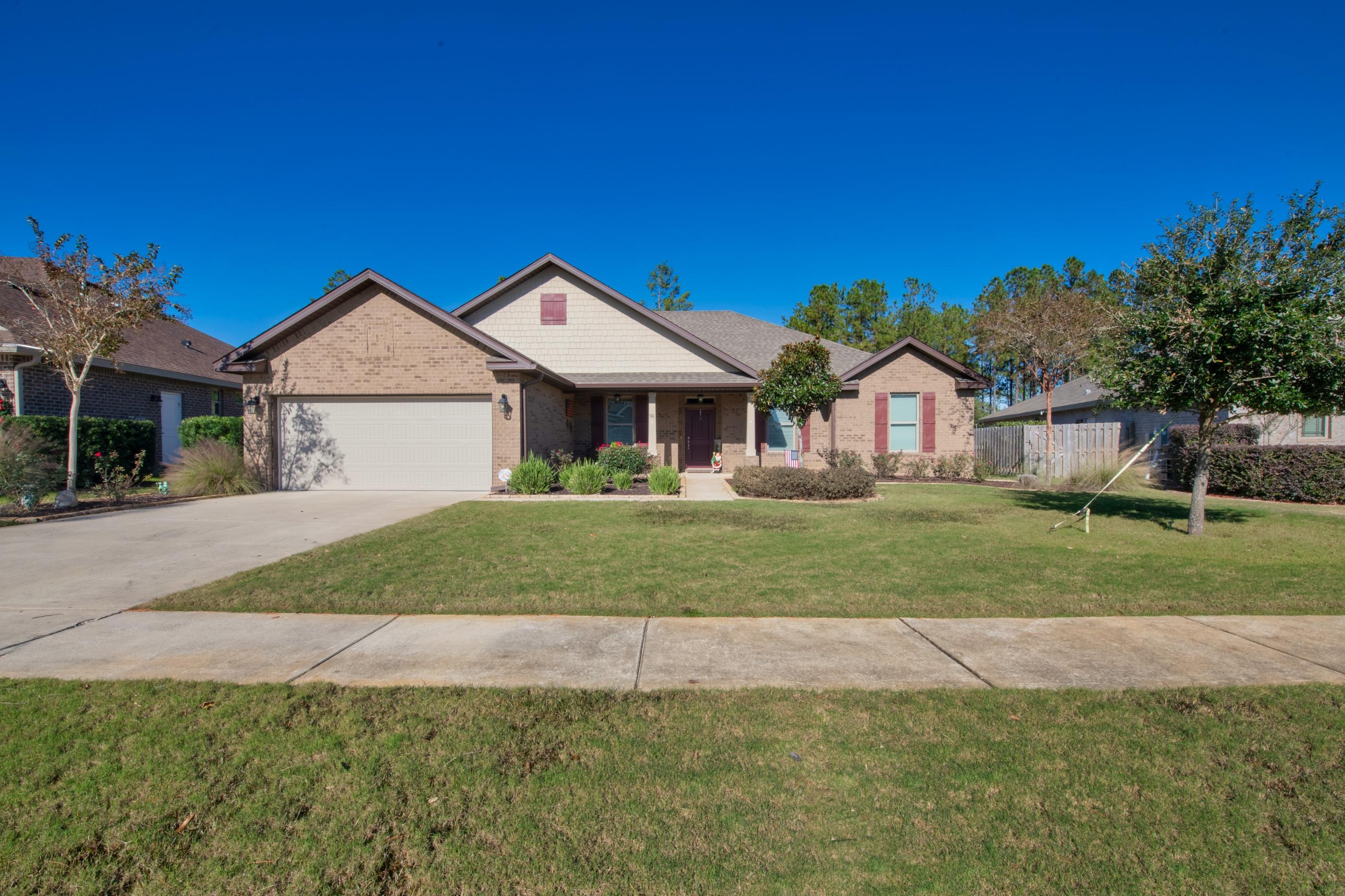 514 Brighton Cove Freeport, FL 32439 - Photo 3 of 32 a front view of a house with a garden and yard
