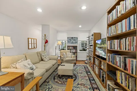 a living room with furniture and a book shelf