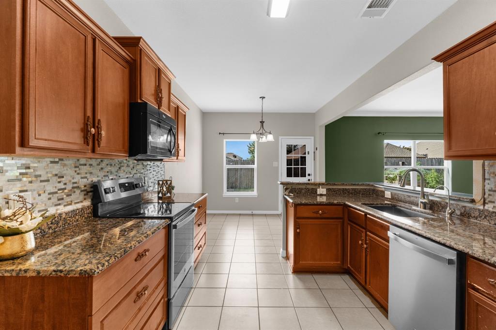 144 Perkins Street Anna, TX 75409 - Photo 7 of 31 a kitchen with stainless steel appliances granite countertop a sink stove and cabinets