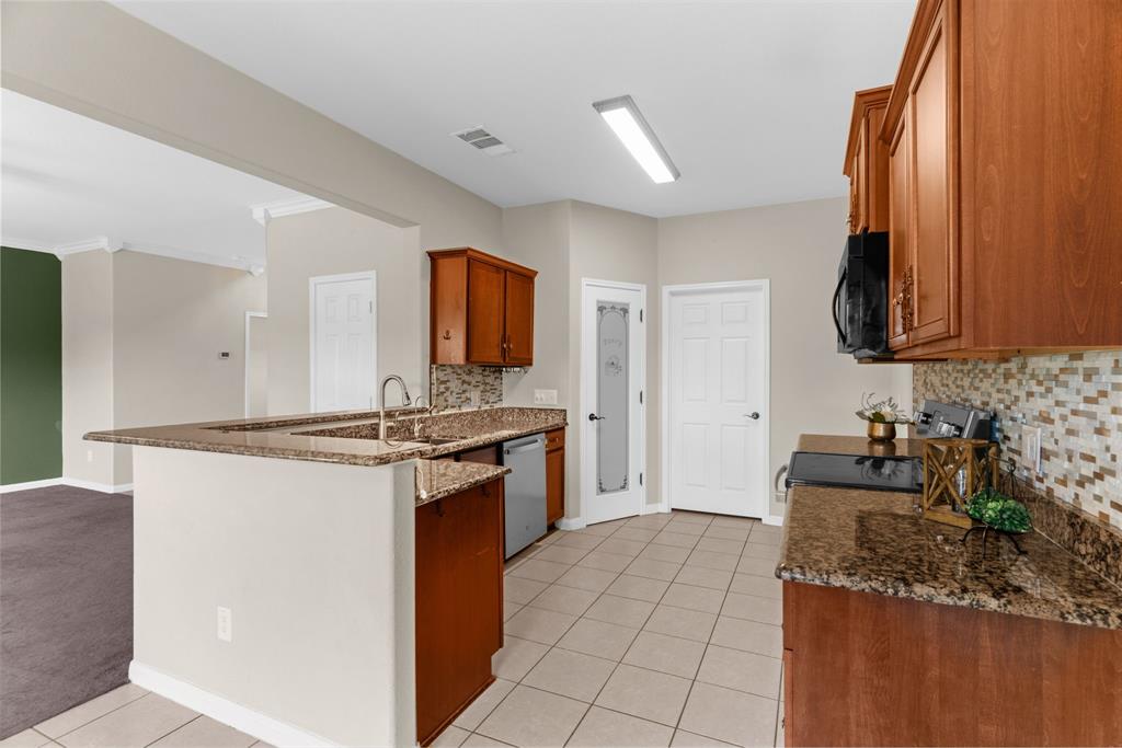 144 Perkins Street Anna, TX 75409 - Photo 8 of 31 a kitchen with granite countertop a sink stove and refrigerator