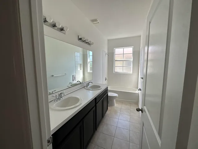 a spacious bathroom with a granite countertop sink mirror and double