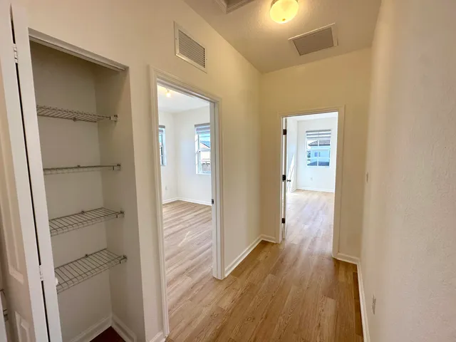a view of a hallway with wooden floor