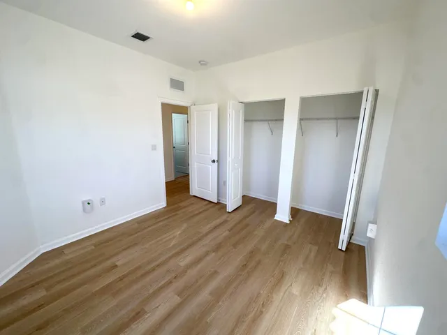 an empty room with wooden floor and closet