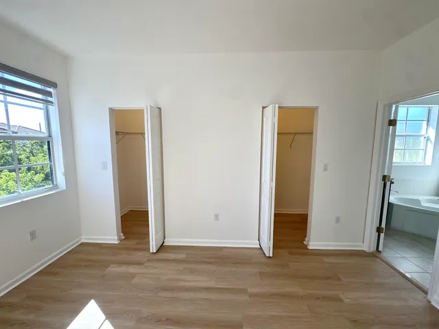 an empty room with closet and windows