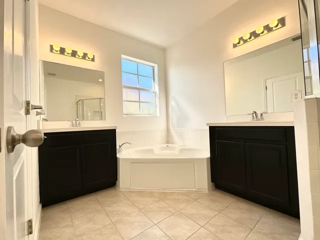 a bathroom with a bathtub sink and mirror