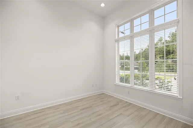 a living room with lots of furniture wooden floor and floor to ceiling windows