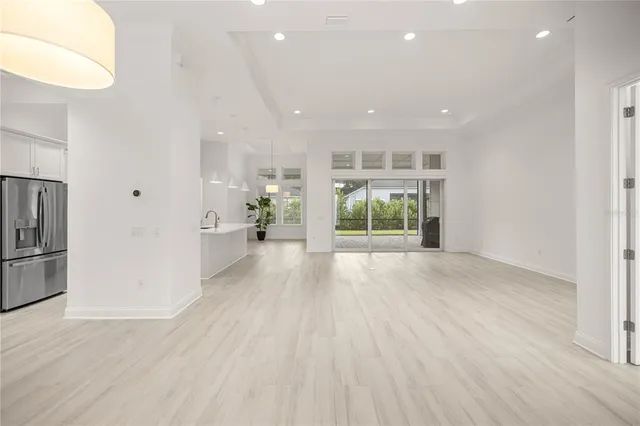 a kitchen with stainless steel appliances a table chairs refrigerator and microwave