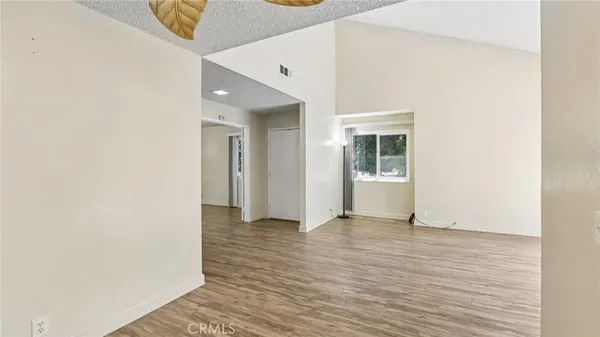 a view of an empty room with wooden floor