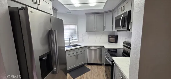 a kitchen with stainless steel appliances a refrigerator a sink a stove a microwave and cabinets